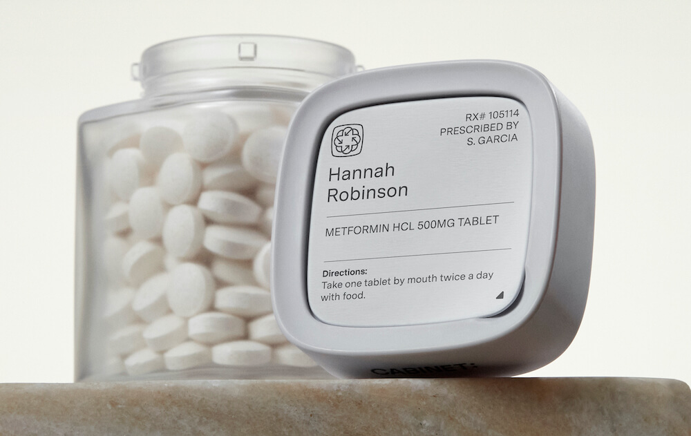 An open glass jar of pills next to its lid, printed with a prescription