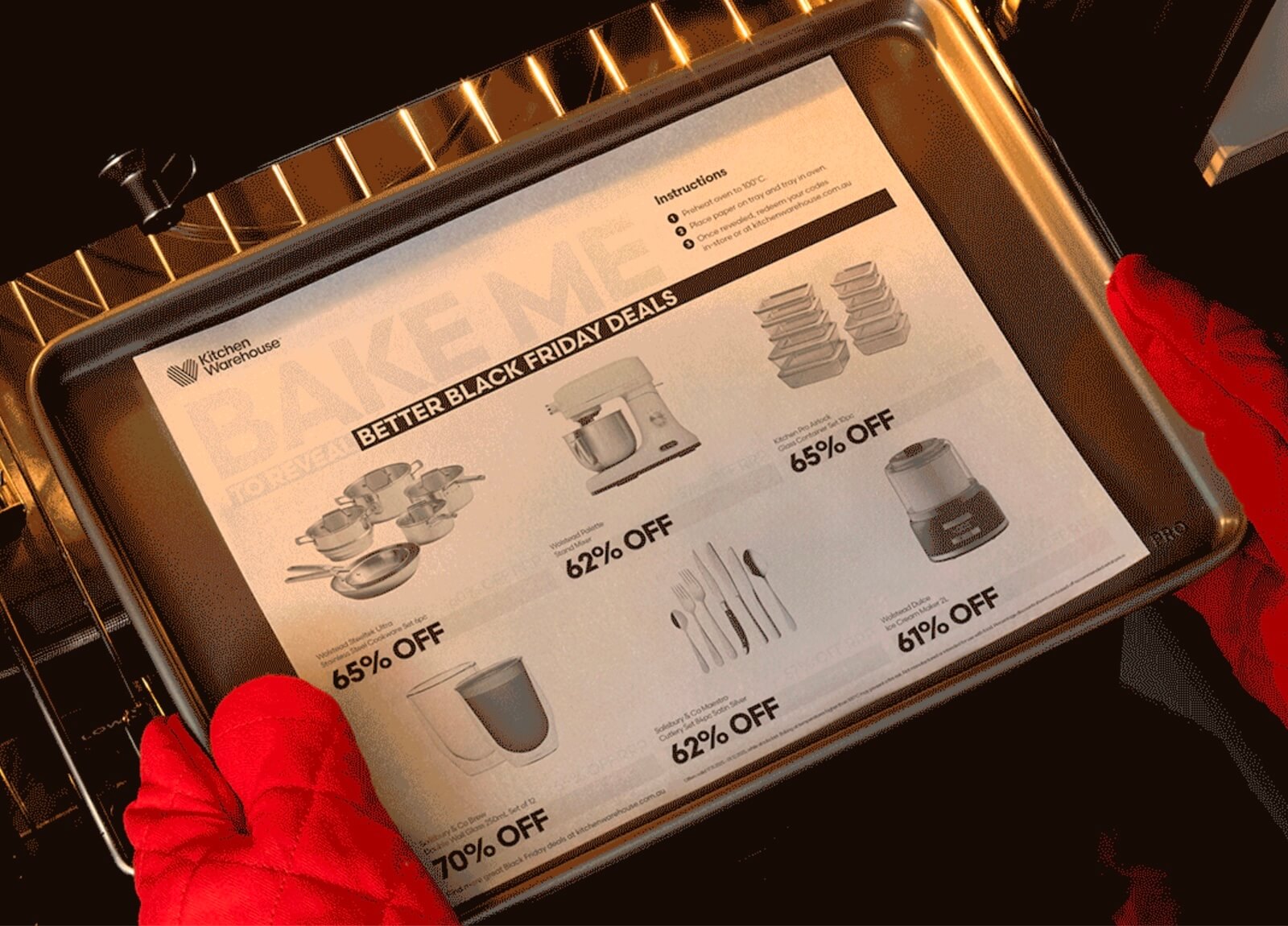 Red oven mitts slide a baking tray into an oven, holding a heat-activated Kitchen Warehouse “Bake Friday” sheet that reveals Black Friday discounts 