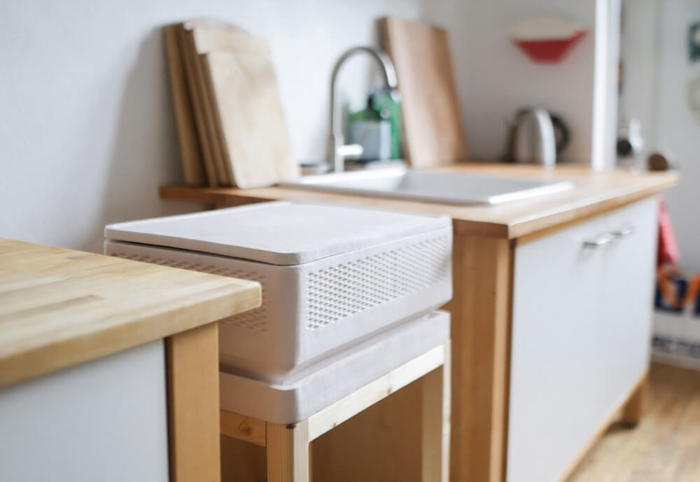 A clay Tony container on a wooden stand, in a light and modern kitchen